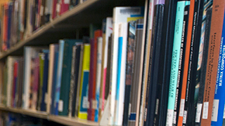 A shelf of books in the library, stacked so far they get blurry in the distance.